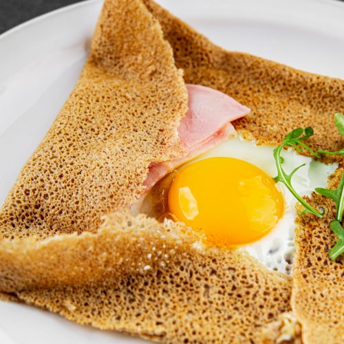 Galette sarrasin fried egg in crepe Breton galette galette complete fresh delicious gourmet food background on the table rustic food top view copy space